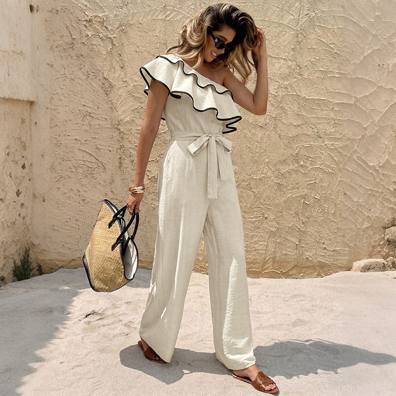Beige one-shoulder ruffle jumpsuit with belted waist and contrast black trim